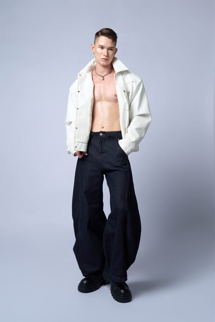 Dee Mak full length in an open white leather jacket, dark wide-leg denim and black boots, hands in pockets